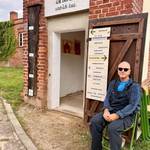 Herr Zöllner sitzt vor dem Eingang seiner Galerie
