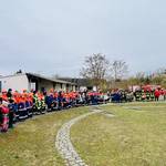 Die Feuerwehrleute und Kitakinder sind im Halbkreis aufgestellt und Hören zwei Feuerwehrleuten zu &copy;EGem Stadt Tangerhütte