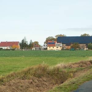 rechts im Vordergrund die Straße nach Ottersburg, im Hintergrund der Ort mit einem großen Gebäude mit PV-Anlage