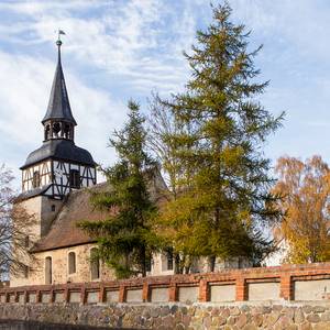 Kirche in Uchtdorf mit Friedhofsmauer im Vordergrund