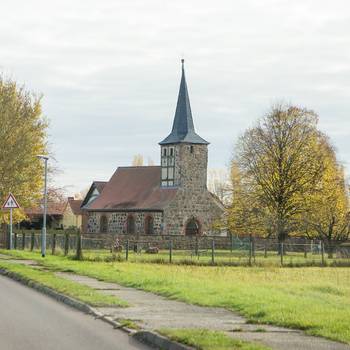 links die Landstraße, im Hintergrund die Kirche von Windberge