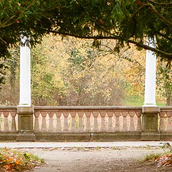 Blick auf die Pergola im Stadtpark gesäumt von Bäumen