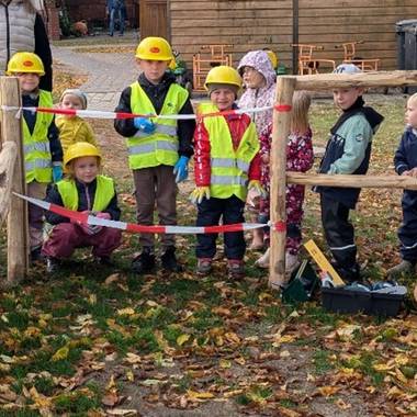 Die Kinder stehen vor ihrer neuen Holzbaustelle und sind begeistert.